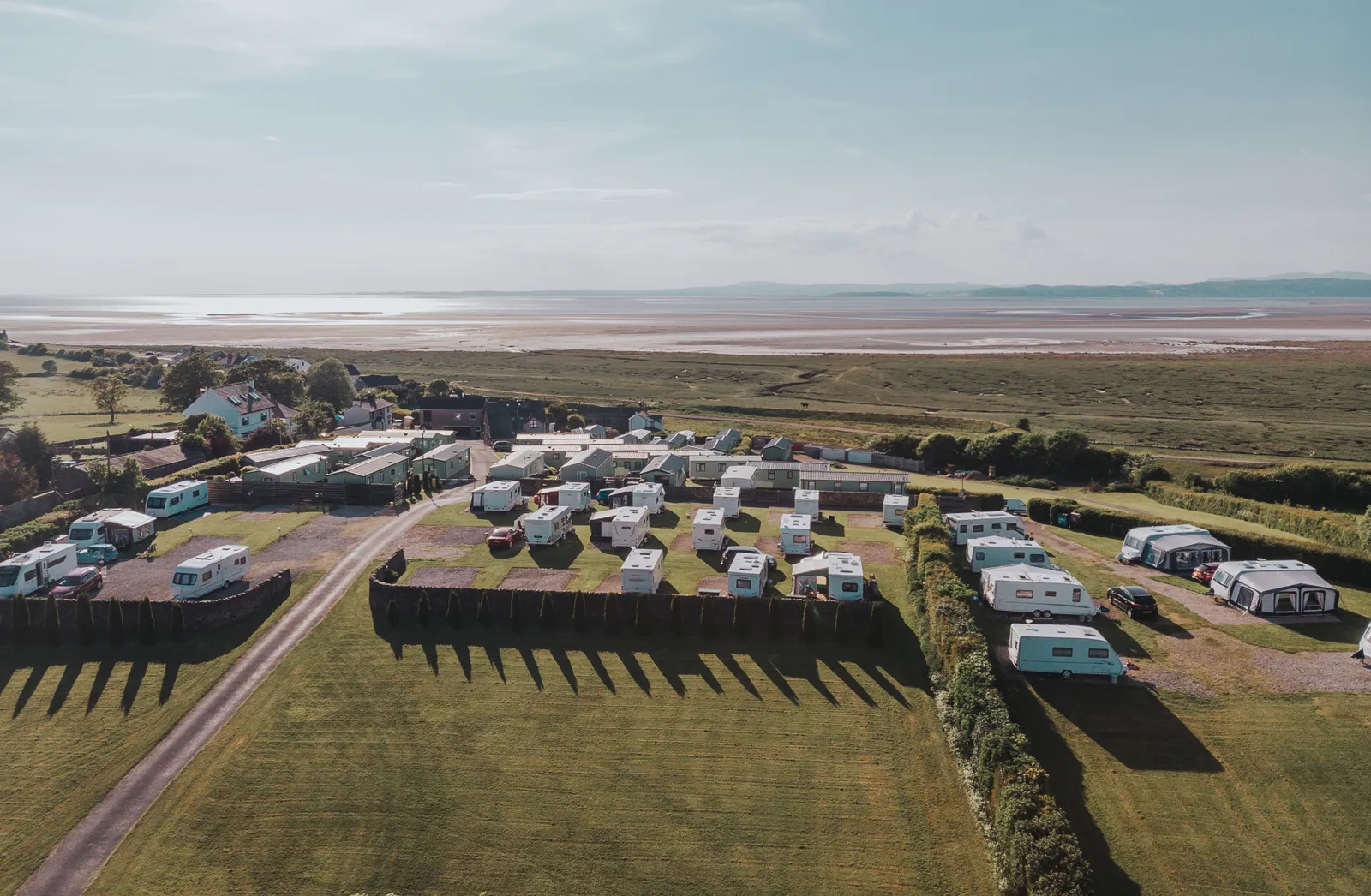 Aerial view of Sandside Caravan Park with Morecambe Bay and the Lake District fells behind